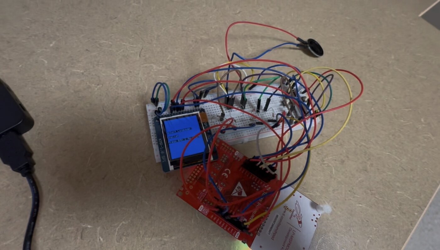 The Connect Four hardware setup: LaunchPad, breadboard, ST7735R LCD showing the language-select screen, and speaker