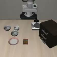 LIBERO-Object simulation environment: a robot arm above a table with bowls, a plate, and a cabinet
