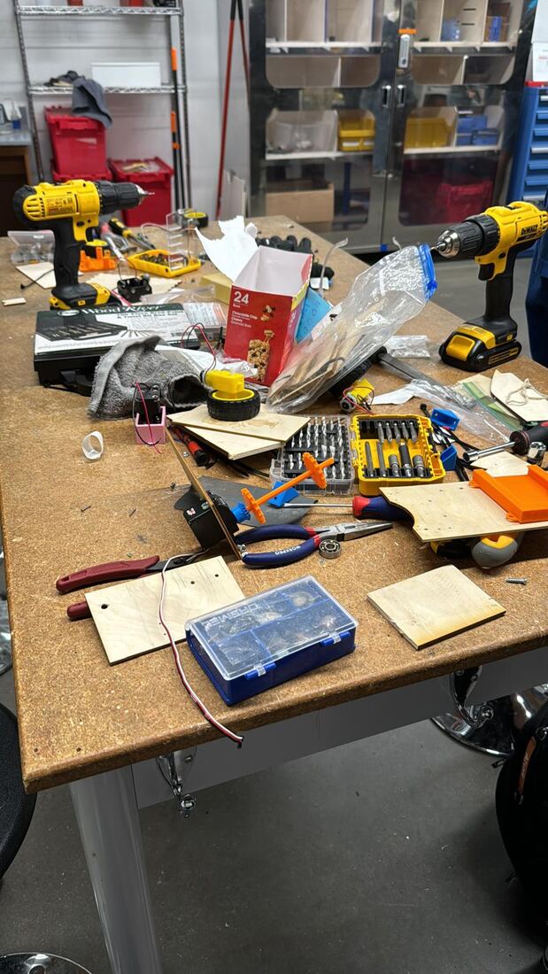 Workbench mid-build with tools and chassis parts